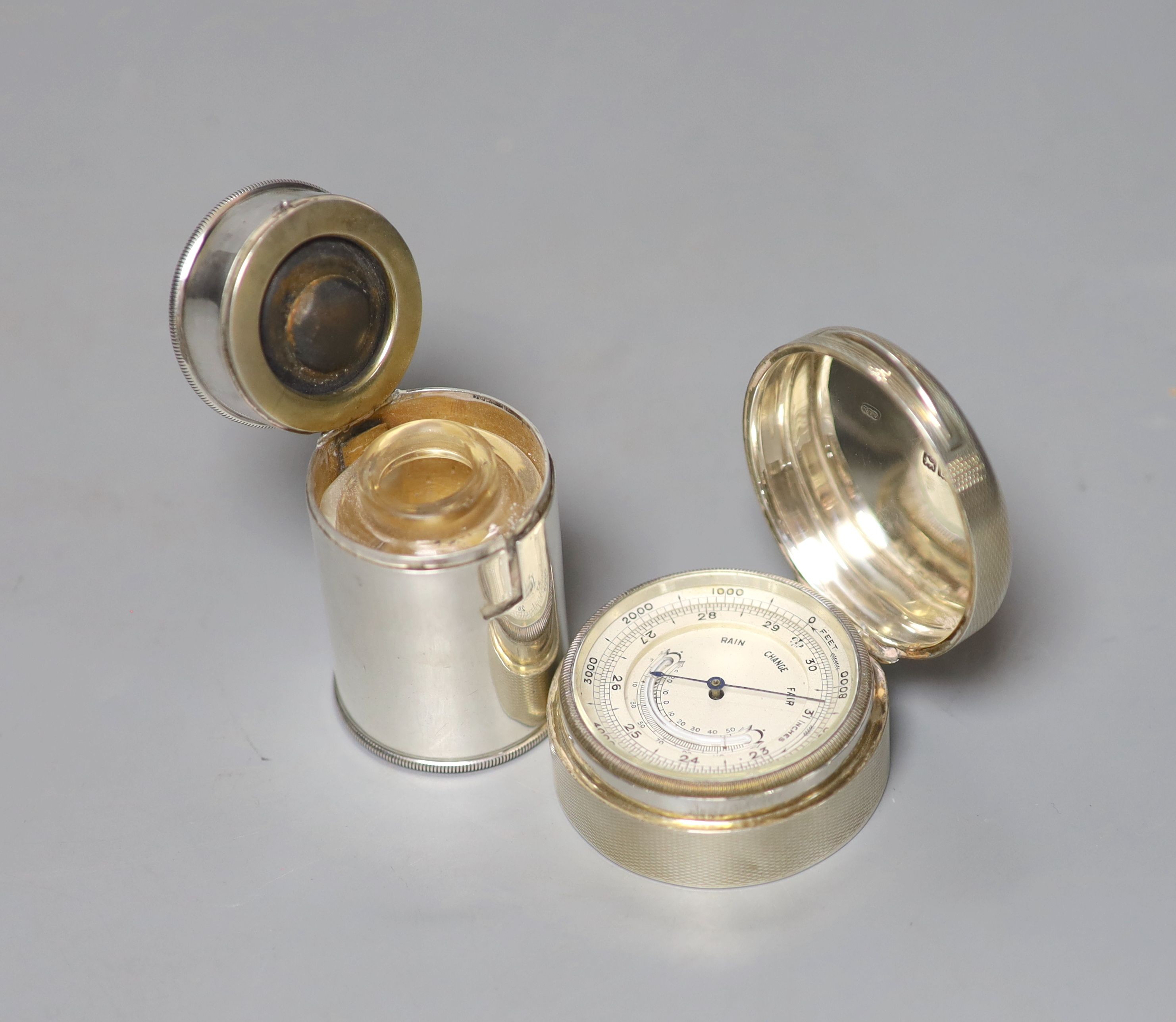 A George V engine turned silver cased barometer, Wright & Davies, London, 1914, 49mm, together with silver cased medicine? bottle, height 49mm.